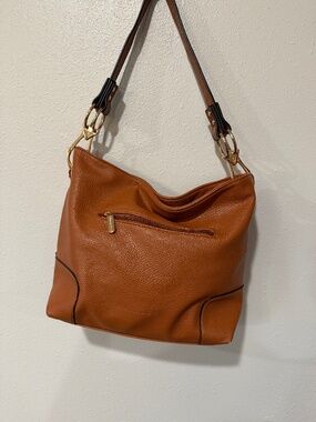 Can Montana West leather handbag featuring a prominent red brand tag inside